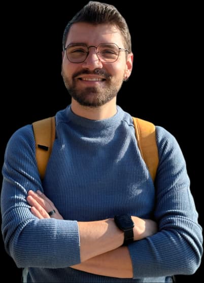 A picture of myself looking at the camera and smiling with my arms folded wearing a blue sweater.